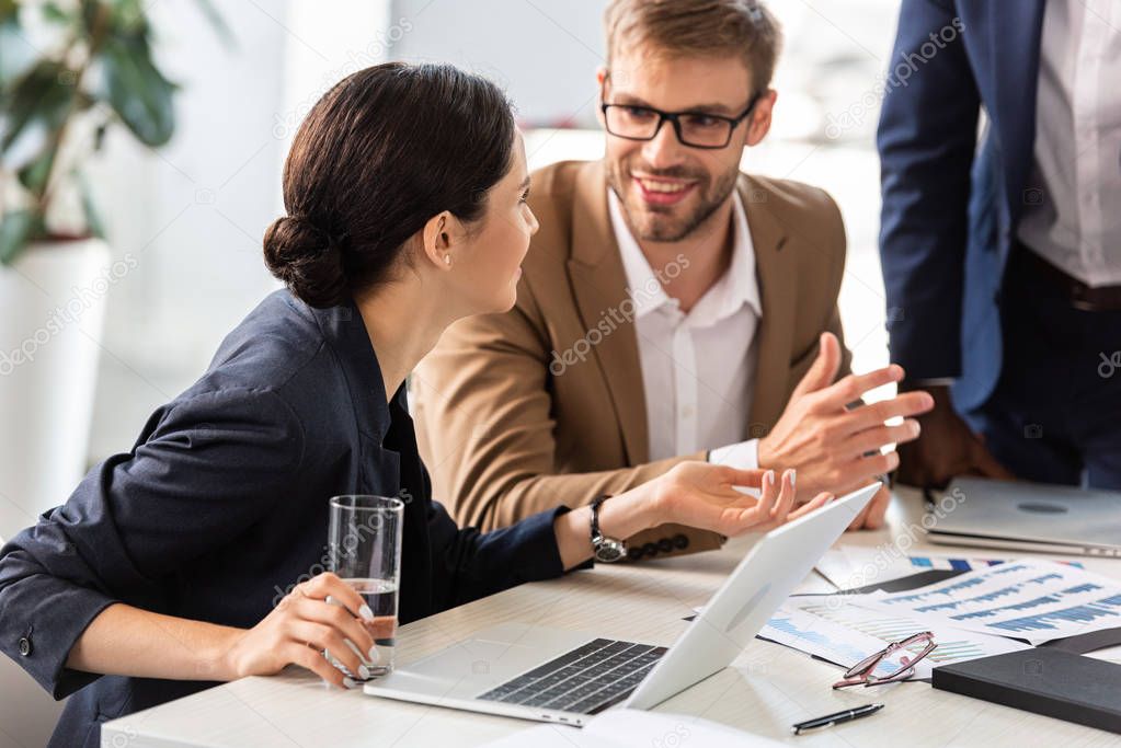 partial view of businesspeople at table during conference in office