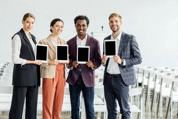 Cuatro Colegas Multiétnicos Sosteniendo Tabletas Digitales Sonriendo Sala Conferencias — Foto de Stock