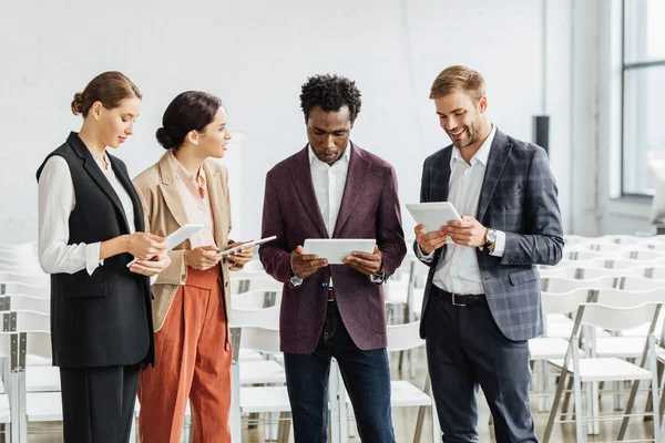 Four Multiethnic Colleagues Holding Digital Tablets Talking Conference Hall — Stock Photo, Image