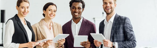 Plano Panorámico Nuestros Colegas Multiétnicos Sosteniendo Tabletas Digitales Sonriendo Sala — Foto de Stock