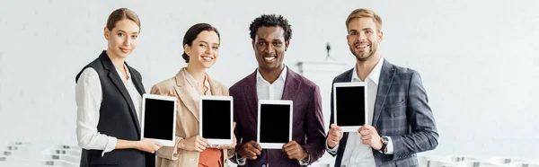 Plano Panorámico Nuestros Colegas Multiétnicos Sosteniendo Tabletas Digitales Sonriendo Sala —  Fotos de Stock