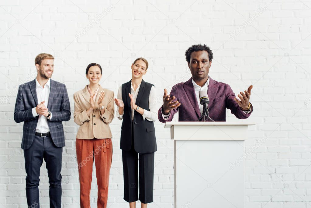 african american businessman in formal wear talking during conference 