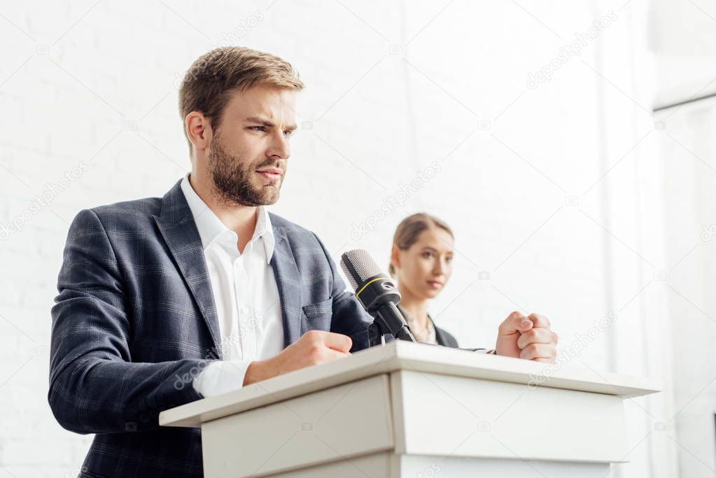 businessman in formal wear talking during conference in conference hall