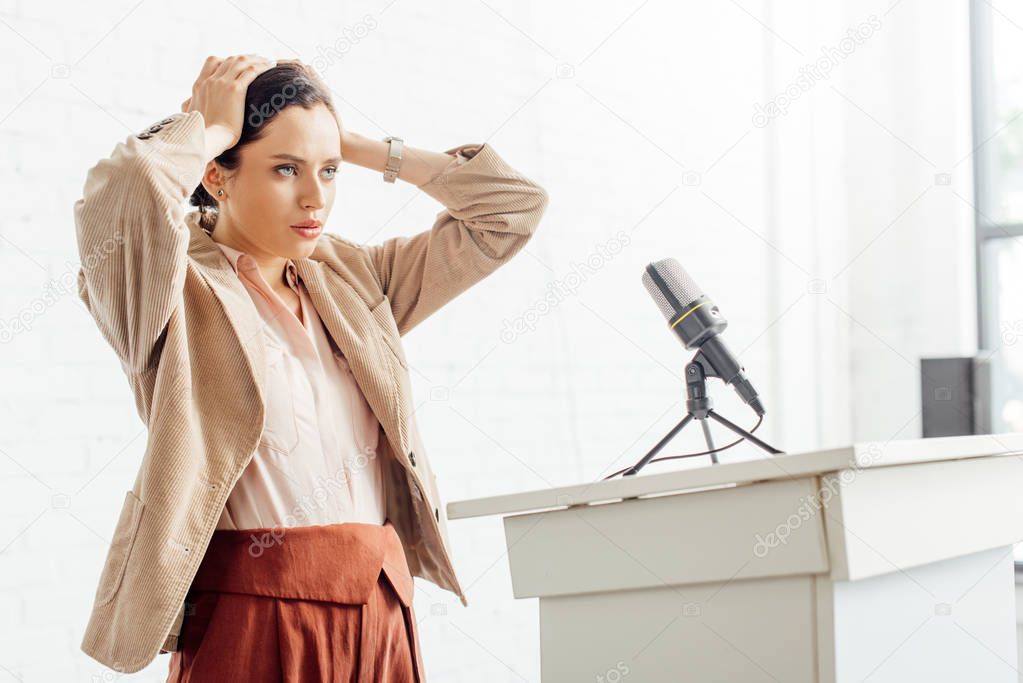 attractive and stressed businesswoman in formal wear looking away during conference