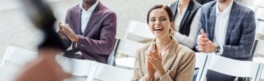 panoramic shot of attractive businesswoman smiling and clapping during conference  clipart