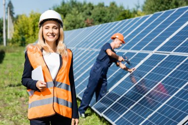 hardhat gülümseyen ve dijital tablet tutan çekici iş kadını 