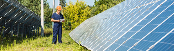 панорамный снимок красивого инженера в комбинезоне и каскаде с цифровым планшетом
 