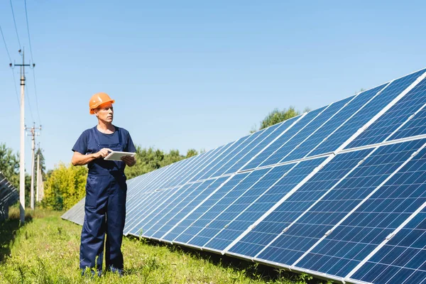 tulum ve hardhat tutan dijital tablet yakışıklı mühendis 