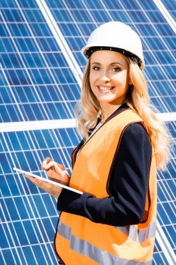 güvenlik yelek ve hardhat gülümseyen ve dijital tablet kullanarak iş kadını 