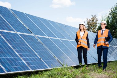 yakışıklı işadamı ve çekici iş kadını güneş enerjisi pilleri yakınında yürüyüş 