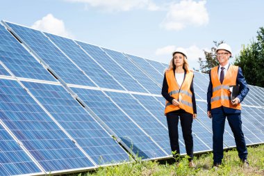 yakışıklı işadamı ve çekici iş kadını güneş enerjisi pilleri yakınında yürüyüş 