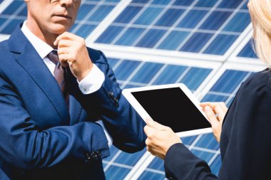 konuşan ve dijital tablet tutan işadamı ve iş kadını kırpılmış görünümü 