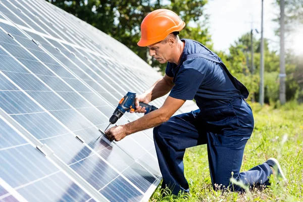 matkap kullanarak t-shirt ve turuncu hardhat yakışıklı mühendis 