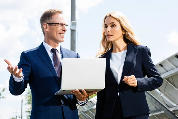 Guapo Hombre Negocios Atractiva Mujer Negocios Hablando Sosteniendo Portátil — Foto de Stock