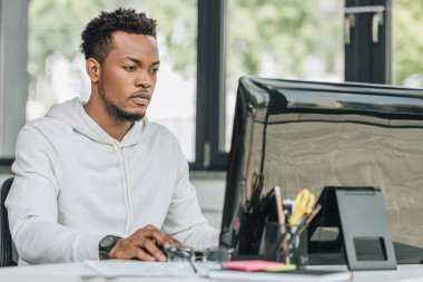 genç afro-amerikan programcı ofiste bilgisayar üzerinde çalışan