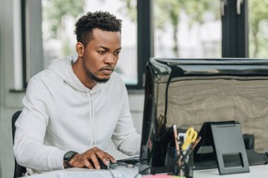 ofiste bilgisayar üzerinde çalışan özenli afro-Amerikan programcı
