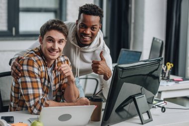 iki neşeli çok kültürlü programcılar kamera bakarak ve başparmak gösteren