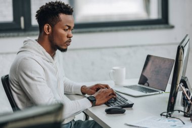 ofiste bilgisayar üzerinde çalışan özenli afro-Amerikan programcı seçici odak