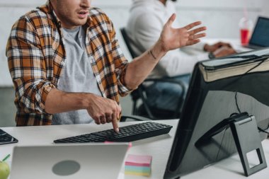 Afro-Amerikan meslektaşıyakınında bilgisayar kullanırken programcı gesturing kırpılmış görünümü