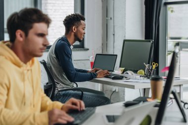 ofiste birlikte çalışan iki genç çok kültürlü programcının seçici odak noktası