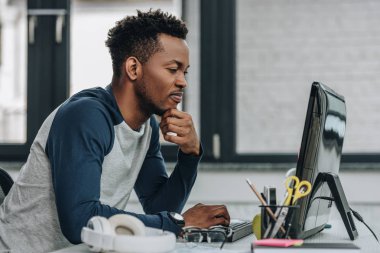 ofiste bilgisayar üzerinde çalışan özenli afro-Amerikan programcı
