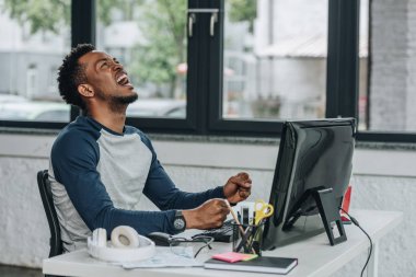 ofiste işyerinde otururken kızgın afro-amerikan programcı gesturing