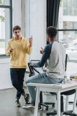 ofiste fikirleri tartışan iki genç çok kültürlü programcı