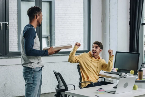 Feliz Programador Mostrando Gesto Mientras Mira Africano Americano Colega Sosteniendo — Foto de Stock