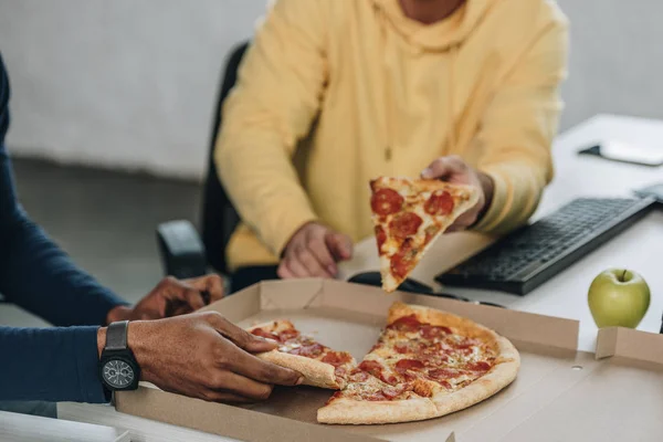 Oříznutý Pohled Dvou Multikulturních Programátorů Kteří Jedí Pizzu Kanceláři — Stock fotografie