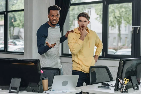 Geïrriteerde Afro Amerikaanse Programmeur Gebaren Terwijl Standing Buurt Van Collega — Stockfoto