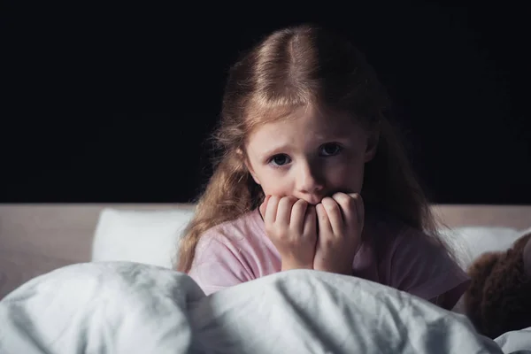 Φοβισμένο Παιδί Κοιτάζοντας Την Κάμερα Ενώ Κάθεται Στο Κρεβάτι Απομονώνεται — Φωτογραφία Αρχείου