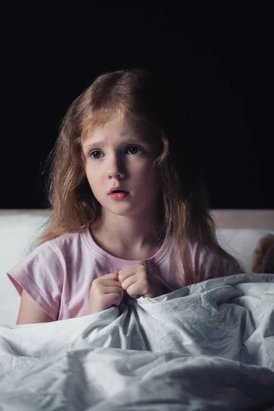 Verängstigtes Kind Schaut Weg Während Auf Bettwäsche Sitzt Isoliert Auf — Stockfoto