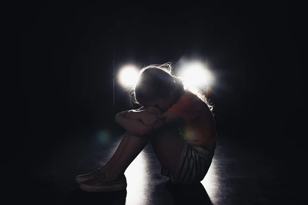 Niño Solitario Sentado Oscuridad Iluminado Con Faros Sobre Fondo Negro — Foto de Stock