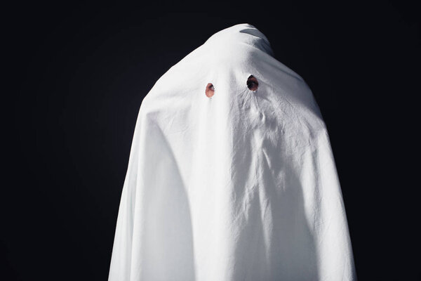 horrible ghost in white bedsheet isolated on black