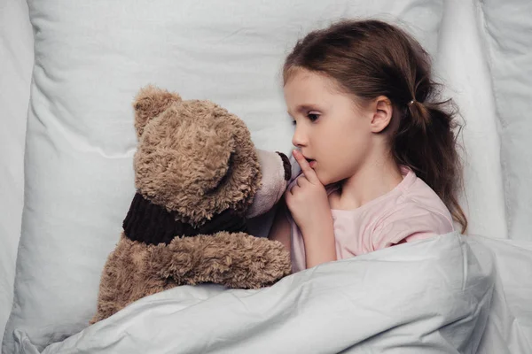 Adorable Child Showing Hush Sign While Lying Bed Teddy Bear — Stock Photo, Image