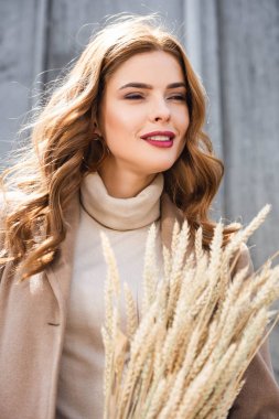 ceket çivi tutan ve uzağa bakan çekici kadın 