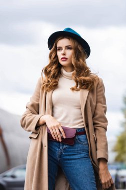 mavi şapka lı ve paltolu çekici kadın uzağa bakıyor 