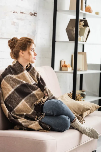 Mulher Atraente Com Cobertor Sentado Sofá Olhando Para Longe — Fotografia de Stock