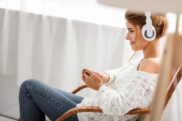 Mulher Atraente Suéter Branco Ouvindo Música Segurando Smartphone — Fotografia de Stock
