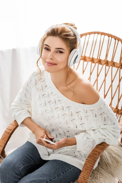 Mulher Atraente Suéter Branco Ouvindo Música Segurando Smartphone — Fotografia de Stock