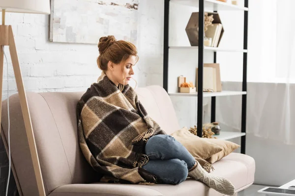 Attractive woman with blanket sitting on sofa in apartment — Stock Image Attractive Woman Blanket Sitting Sofa Apartment Stock Picture