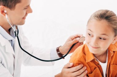 beyaz önlükte pediatrist beyaz izole stetoskop ile çocuk inceleyen