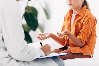 klinikte çocuk incelerken panoda pediatrist yazının kısmi görünümü