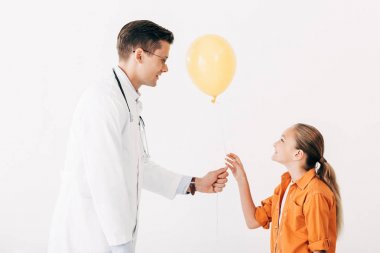 beyaz ceketli pediatrist çocuk çocuk beyaz izole sarı balon veren