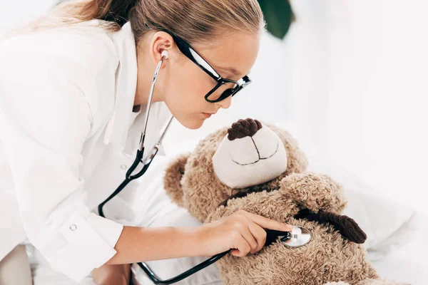 Kid Doktor Kostym Undersöker Nallebjörn Med Stetoskop — Stockfoto