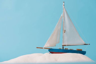decorative ship in white sand isolated on blue clipart