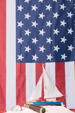 Amerikan ulusal bayrak arka plan üzerinde pusula ve teleskop yakın beyaz kum dekoratif gemi
