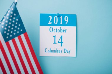 mavi arka plan üzerinde Amerikan ulusal bayrağı yakınında Columbus Günü yazıt ile kağıt takvim