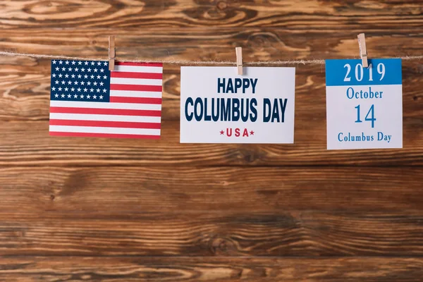 卡与快乐哥伦布日铭文附近的美国国旗和日历纸片与10月14日日期在木制表面 — 图库照片