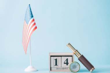 mavi arka plan üzerinde Amerikan bayrağı, pusula ve teleskop yakın 14 Ekim tarih ile ahşap takvim 